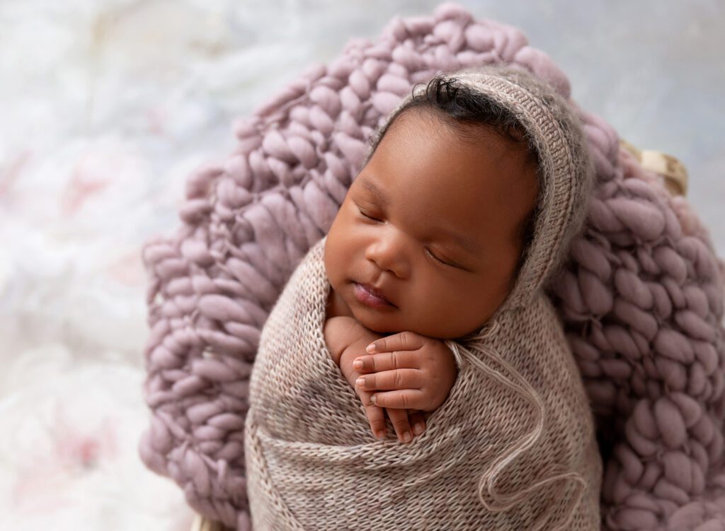 Newborn girl wrapped in lavender for portrait session with New York baby and family photographer