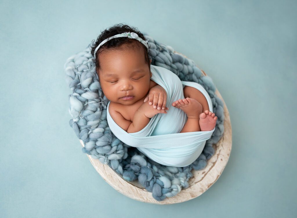 Baby girl in mint wrap asleep in rustic wooden bowl prop Brooklyn Ny