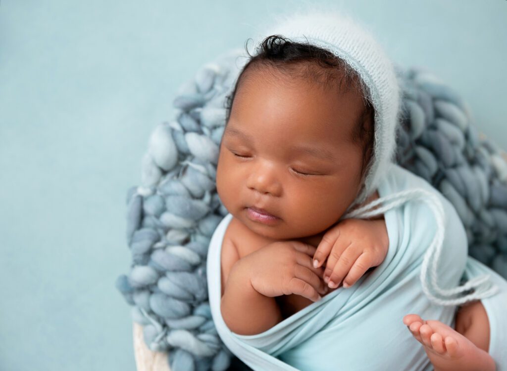 Baby girl swaddled in min blue wrap newborn photos in Brooklyn NY