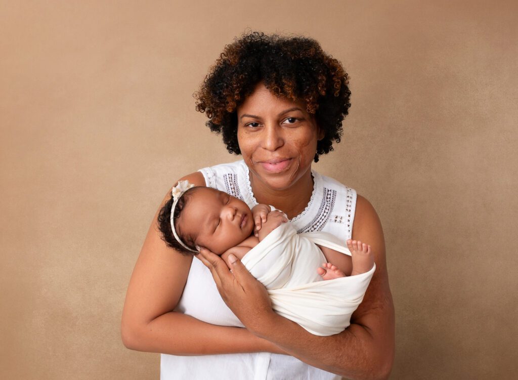Newborn baby girl being held by Mom in Brooklyn, NY photo studio