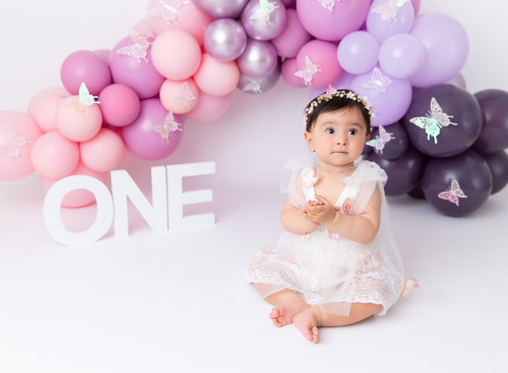 Baby girl cake smash photos pink lilac purple balloon garland Brooklyn NYC