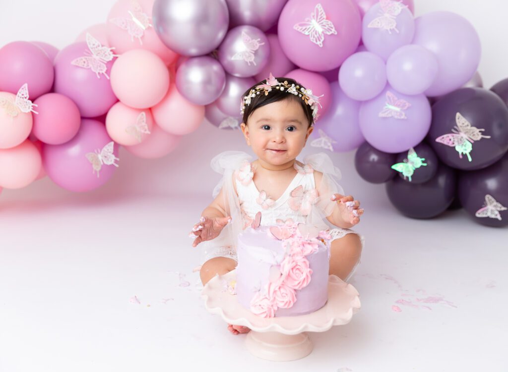 Baby girl cake smash photos pink lilac purple balloon garland Brooklyn NYC