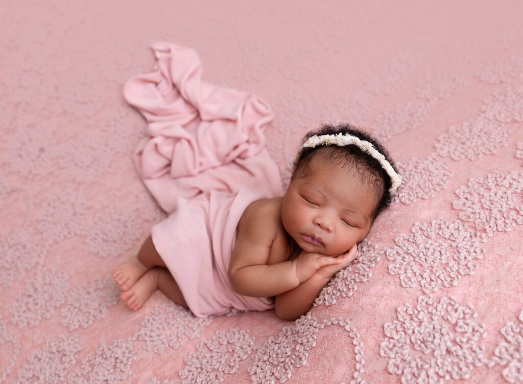 African American baby asleep on pink beanbag in Brooklyn, NY photo studio